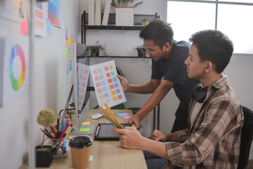 Closeup of Hands Comparing Printed Color Swatches With Digital Design Mockups