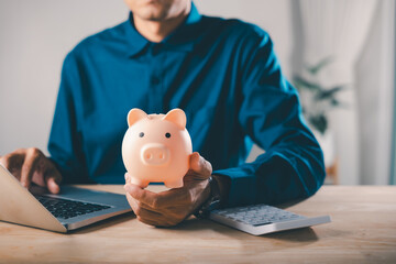 Man holds piggy bank car bank learning e education financial online money elearning internet, using laptop and calculator to manage monthly costs for professional study course plan