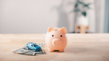 Piggy bank money car gdp savings insurance finance health budget save, blue toy vehicle on dollar bills represents automotive growth or financial investment strategy plan concept