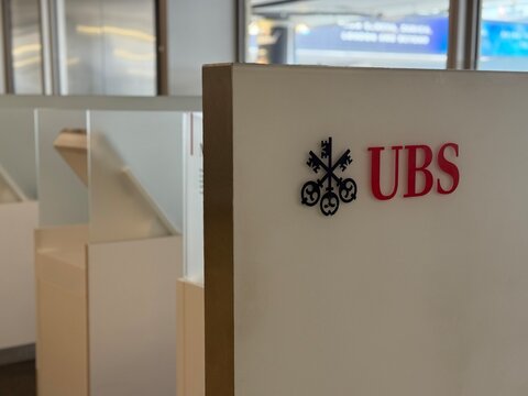 Geneva, switzerland - June 13 2025: A partial view shows the red UBS logo on a white wall with the symbol of keys to the left of the lettering inside an office setting.