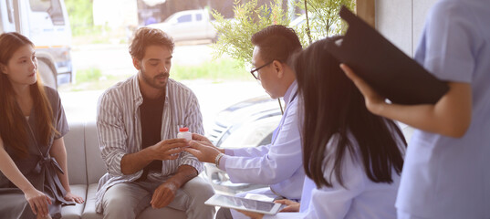 Male and female doctors are discussing checking a patient's temperature at the clinic.	