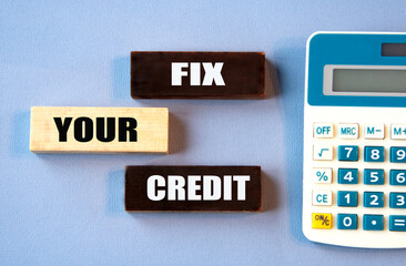 FIX YOUR CREDIT - words on wooden colored blocks against a calculator background