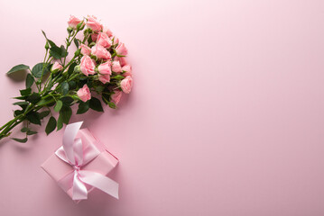 Gift, present box decorated with pink ribbon bow, rose flower bouquet on pink background. Valentine's day, 14 February, birthday, 8 march women's day gift. Love and romance. Spring.