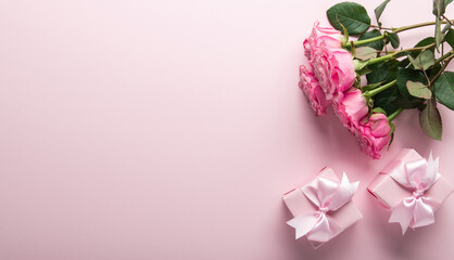 Gift, present box decorated with pink ribbon bow, rose flower bouquet on pink background. Valentine's day, 14 February, birthday, 8 march women's day gift. Love and romance. Spring.