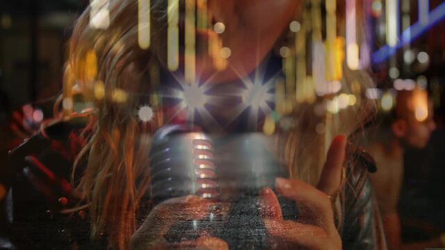 Music industry singer gripping mic causing lens flares spotlighting note with guitarist strumming