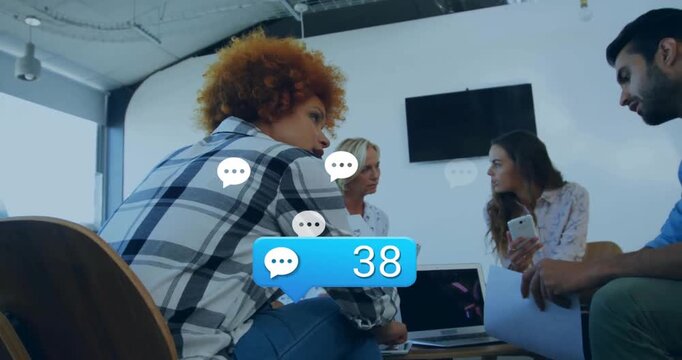 Business team reviewing laptop on chat bubble generating icons, incrementing blue comment count