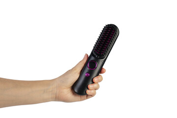 Obraz premium A black electric hair comb in a hand against a transparent background.