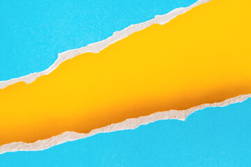 uneven torn blank blue paper on grunge yellow paper, top view