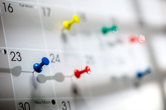 Calendar appointment thumbtacks in various dates on calendar diary
