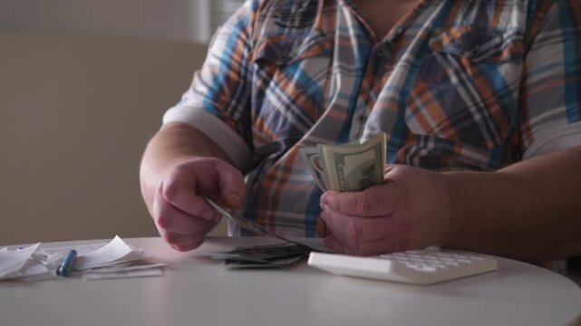 Individual Organizes Funds At Home, Man Carefully Sorts Bills And Calculates Savings Quietly, Man Methodically Reviews And Sorts Personal Financial Documents In Peaceful Home Setting