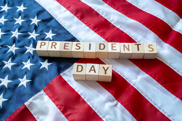 PRESIDENT'S DAY word made by wooden blocks over United States of America flag