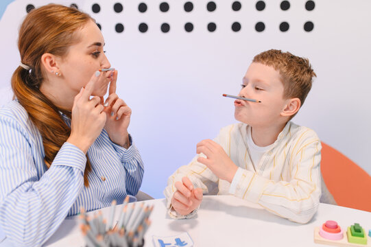 Speech therapist helping young boy with articulation exercises