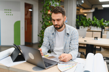 Interior designer working on project plans in office