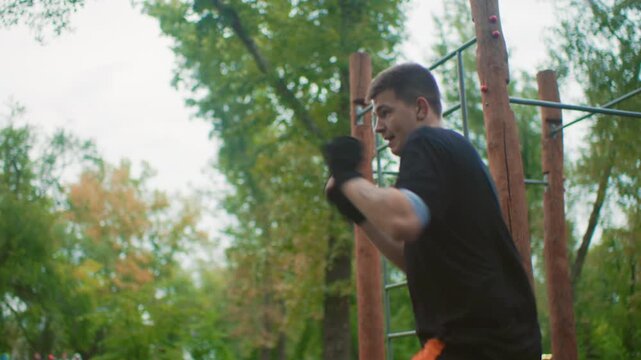 close range power punching workout outdoors featuring man delivering heavy strikes and uppercuts, intense focus and explosive movement, boxing gloves and muscular tension, quick recovery steps