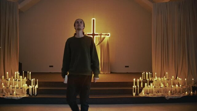 Worshipper departs, his silhouette framed by the luminous cross he just prayed before.