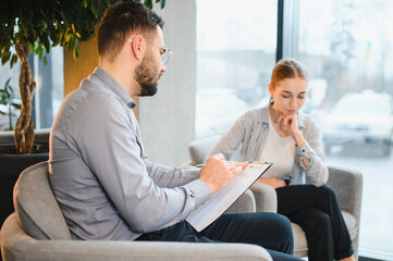 Obraz premium Psychologist counseling young woman during therapy session