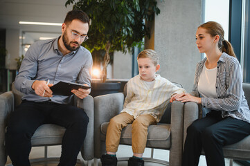 Psychologist counseling mother and child during therapy session