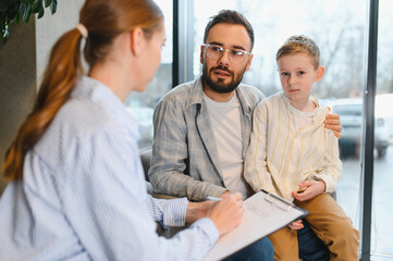 Obraz premium Father and son consulting child psychologist for therapy session