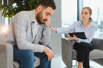 Man talking with psychologist undergoing therapy session