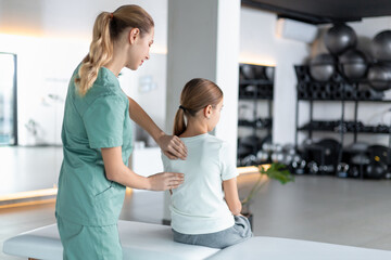 Fototapeta premium Woman therapist working with girl during rehab session