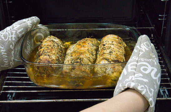 Pyszny domowy pieczony schab wieprzowy w ziołach wyciągany z piekarnika w szklanym naczyniu żaroodpornym