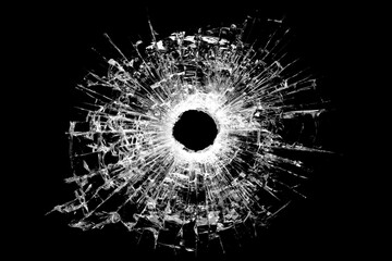 Bullet hole cracked glass with spiderweb fracture on black background © Joy Mohanta