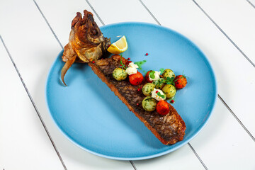 grilled fish with vegetables at a blue plate