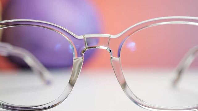 Clear eyeglasses with transparent frames against a colorful background