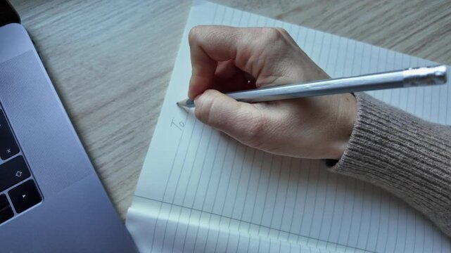 A hand holding a pencil writes a To Do list on a lined sheet of paper, symbolizing planning, productivity, and organization. Illustrations for articles on time management
