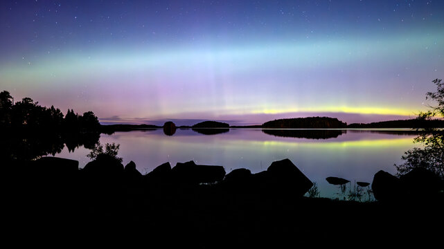 Scenic view at lake against at night. Northern lights dancing after the sunset.