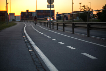 Fototapeta premium pista ciclabile che si estende lontano in un ambiente urbano in Slovenia, al tramonto
