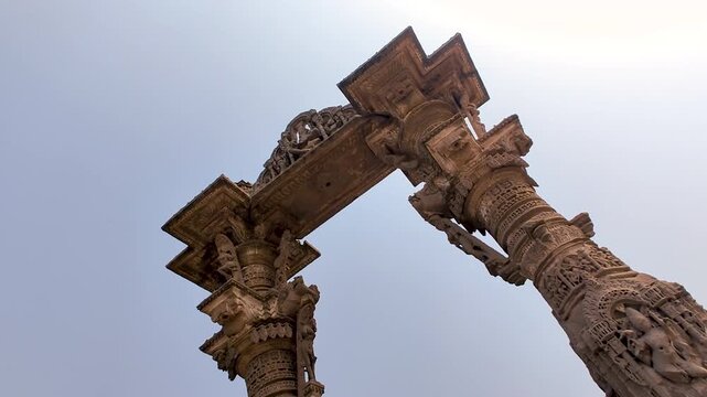 Vadnagar, Gujarat, India low angle Kirti Toran gateway showing ancient stone architecture, carved pillars, historic monument, Indian cultural heritage, temple era craftsmanship, and tourism landmark.