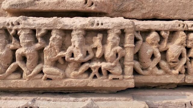 Vadnagar, Gujarat, India ancient Kirti Toran stone relief band showing carved human figures and pillars, historic Indian architecture, cultural heritage, archaeological monument, and temple era art.