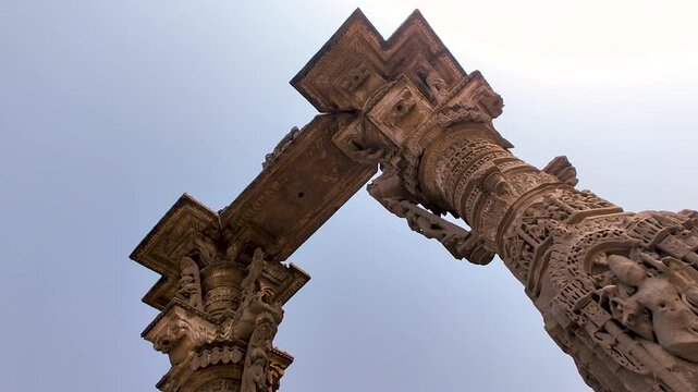 Vadnagar, Gujarat, India low angle Kirti Toran stone pillars showing ancient Indian architecture, carved monument details, cultural heritage, temple era craftsmanship, and historic tourism landmark.
