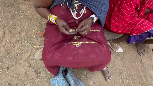 Maasai woman making traditional jewelry in a village near Ngorongoro in Tanzania.
