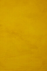 Obraz premium Solid yellow plaster surface with soft matte finish, fine brush marks and gentle tonal variation. Clean minimal background with warm color, tactile depth and open negative space. Copy space