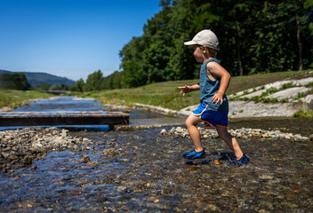 Cool mountain stream is a place for children to have fun during the hot summer