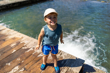 Delighted child smiles while having fun in a mountain stream
