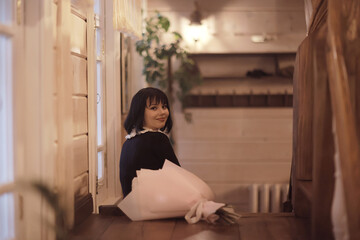 model a young woman posing with a bouquet of flowers indoors