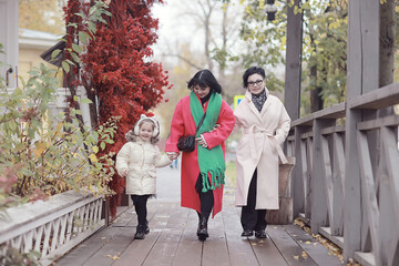 family on a walk, women, daughter, mother, grandmother and granddaughter in the autumn city outside