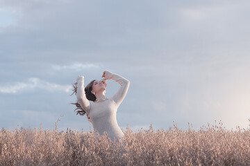 Summer Look female model posing in a field against the sky, the concept of natural freedom and femininity