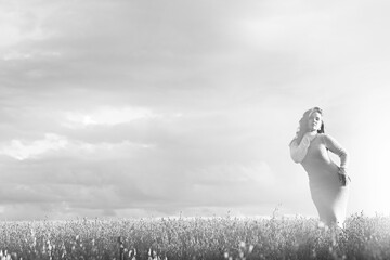 Summer Look female model posing in a field against the sky, the concept of natural freedom and femininity