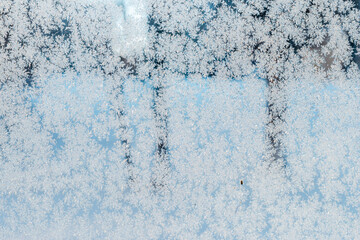 Frosted winter window with frozen snowflake texture.