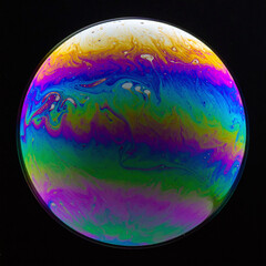 Vibrant macro shot of an iridescent soap bubble resembling a mysterious planet. Swirling neon colors on a dark background offer a surreal, abstract look for creative and scientific uses.