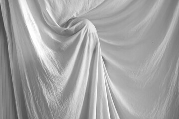 silhouette of a person against the background of a white sheet, the effect of a statue or a ghost