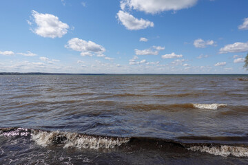 Windy lake with small waves under blue sky
