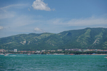 Fototapeta premium Coastal town with green hills and blue sea view