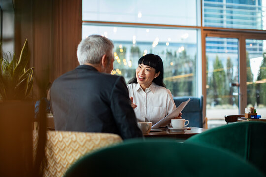 Business colleagues meeting over coffee in modern cafe