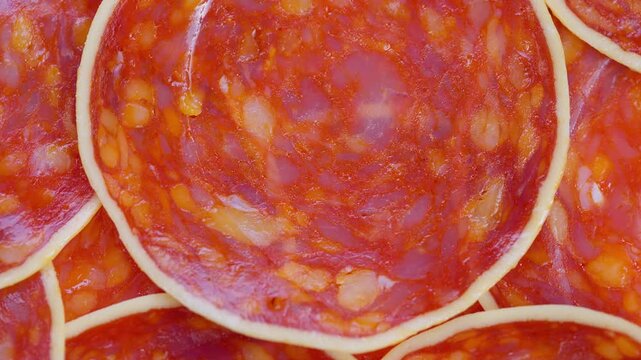 Closeup of seasoned sausage slices, Detailed view of seasoned meat with marbling, Highly detailed image showing overlapping sausage slices with spices and rich coloration