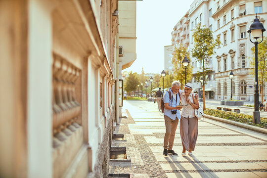 Senior couple sightseeing on a sunny european city boulevard